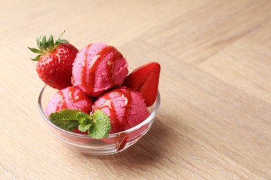 Photo of Refreshing sorbet with syrup, strawberries and mint in bowl on wooden table, closeup. Space for text