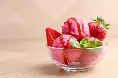 Photo of Refreshing sorbet with syrup, strawberries and mint in bowl on wooden table, closeup. Space for text
