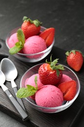 Photo of Refreshing sorbet, strawberries, mint and spoons on grey textured table, closeup