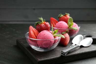 Photo of Refreshing sorbet, strawberries, mint and spoons on grey textured table, closeup