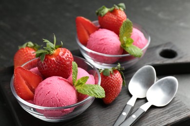 Photo of Refreshing sorbet, strawberries, mint and spoons on grey table, closeup