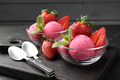 Photo of Refreshing sorbet, strawberries, mint and spoons on grey table, closeup