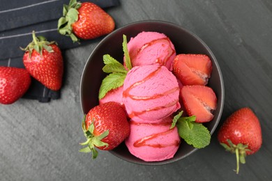 Photo of Refreshing sorbet with syrup, strawberries and mint in bowl on grey textured table, flat lay. Space for text