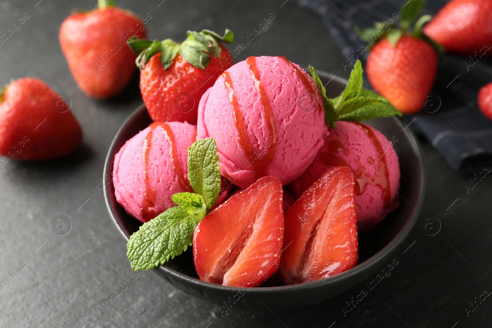 Refreshing sorbet with syrup, strawberries and mint in bowl on grey textured table, closeup Photo of Refreshing sorbet with syrup, strawberries and mint in bowl on grey textured table, closeup