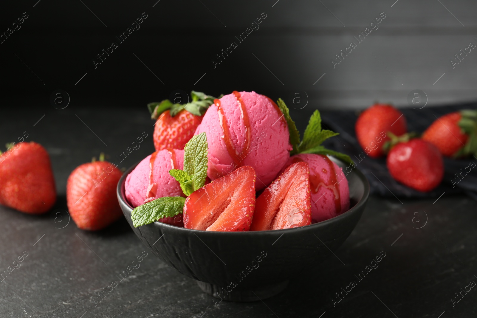 Refreshing sorbet with syrup, strawberries and mint in bowl on grey textured table, closeup Photo of Refreshing sorbet with syrup, strawberries and mint in bowl on grey textured table, closeup