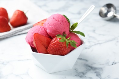 Photo of Refreshing sorbet, strawberries and mint in bowl on white marble table, closeup