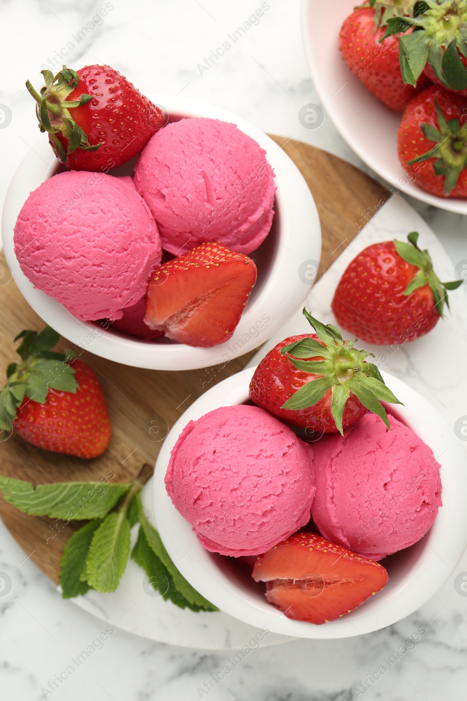 Refreshing sorbet, strawberries and mint on white marble table, flat lay Photo of Refreshing sorbet, strawberries and mint on white marble table, flat lay
