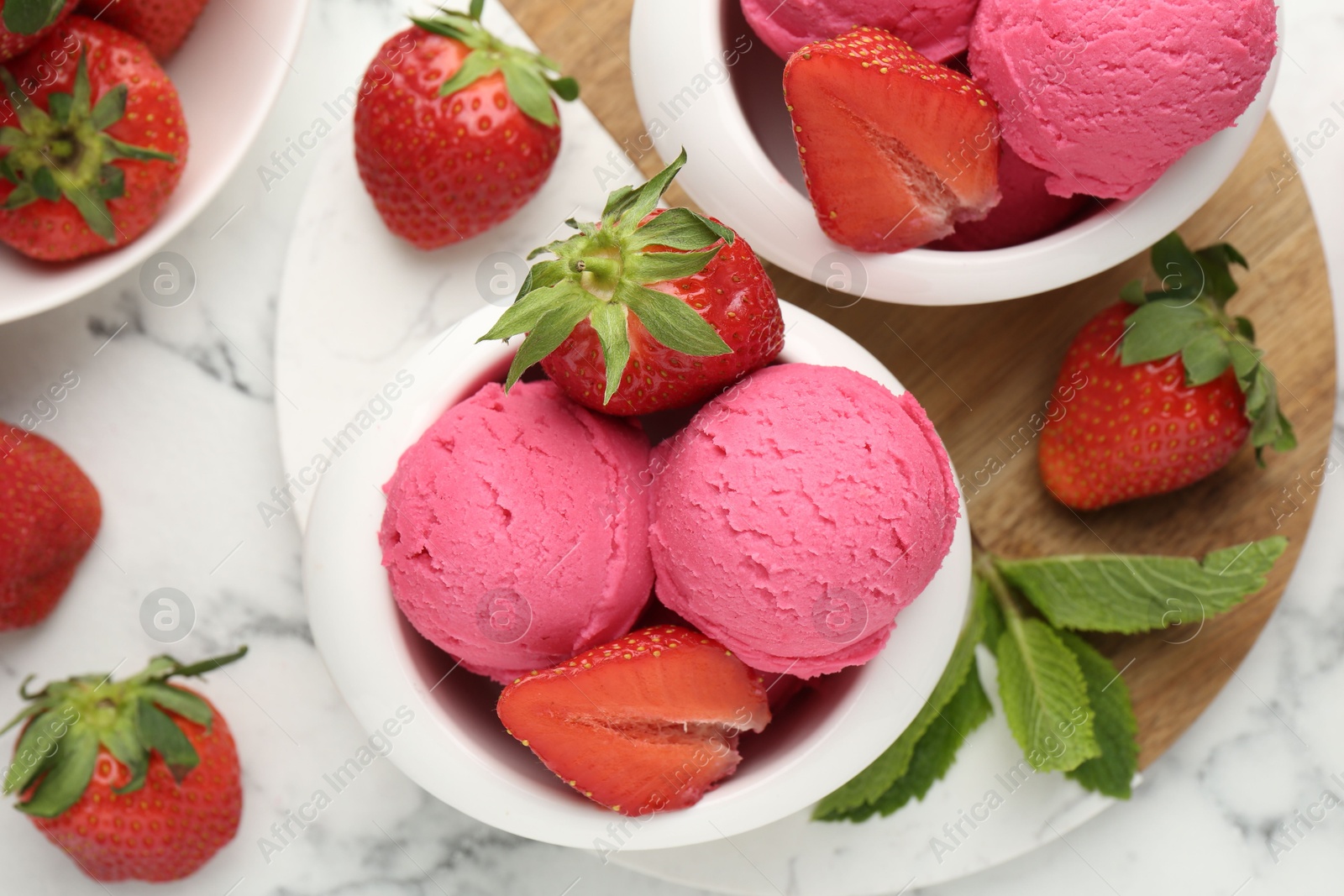 Photo of Refreshing sorbet, strawberries and mint on white marble table, flat lay