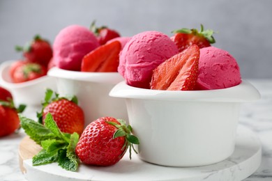 Photo of Refreshing sorbet, strawberries and mint on white marble table against grey background, closeup
