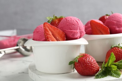 Photo of Refreshing sorbet, strawberries and mint on white marble table against grey background, closeup
