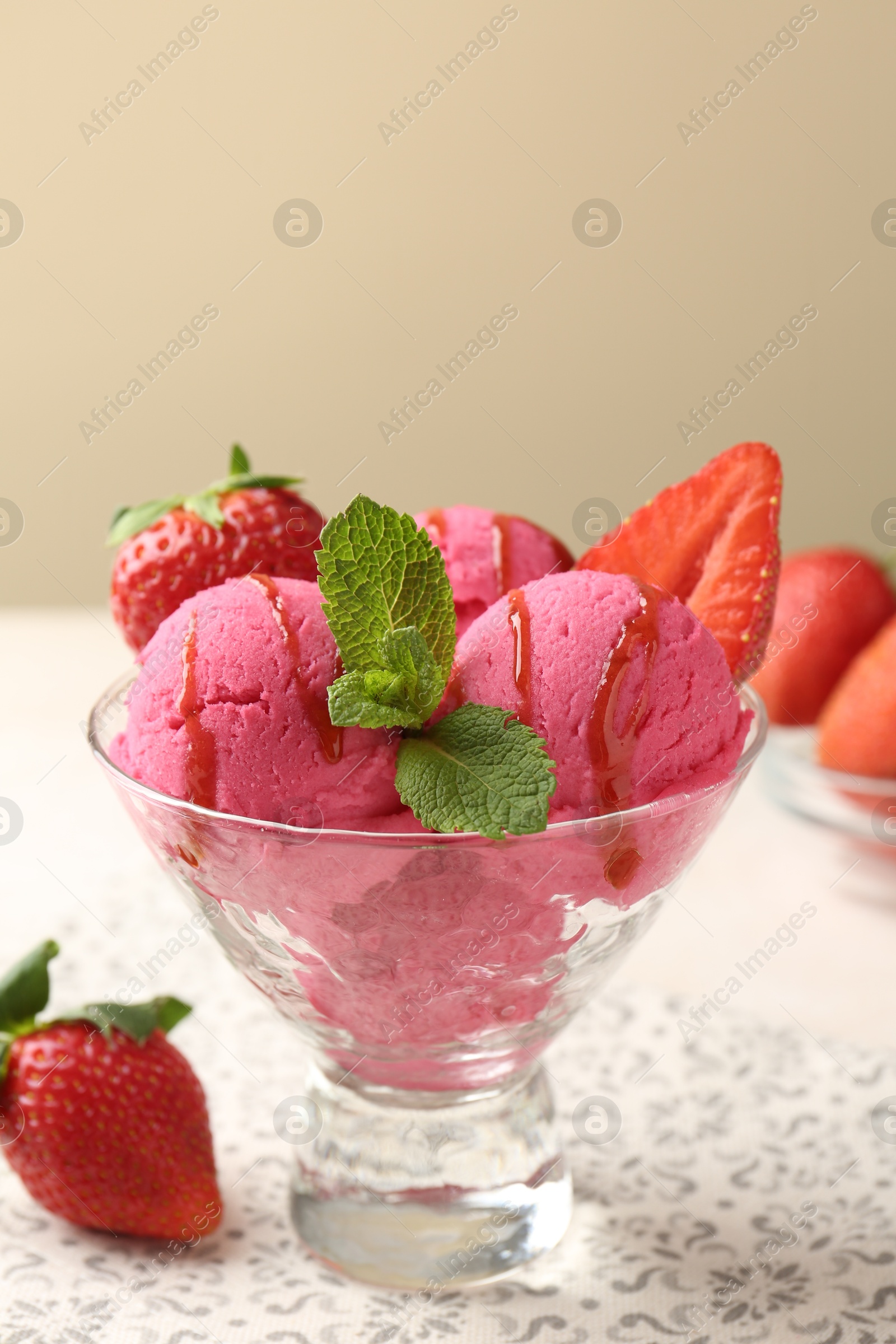 Refreshing sorbet with syrup, strawberries and mint in dessert bowl on white table against beige background, closeup Photo of Refreshing sorbet with syrup, strawberries and mint in dessert bowl on white table against beige background, closeup