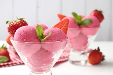 Photo of Refreshing sorbet, strawberries and mint in dessert bowl on white table against grey background, closeup