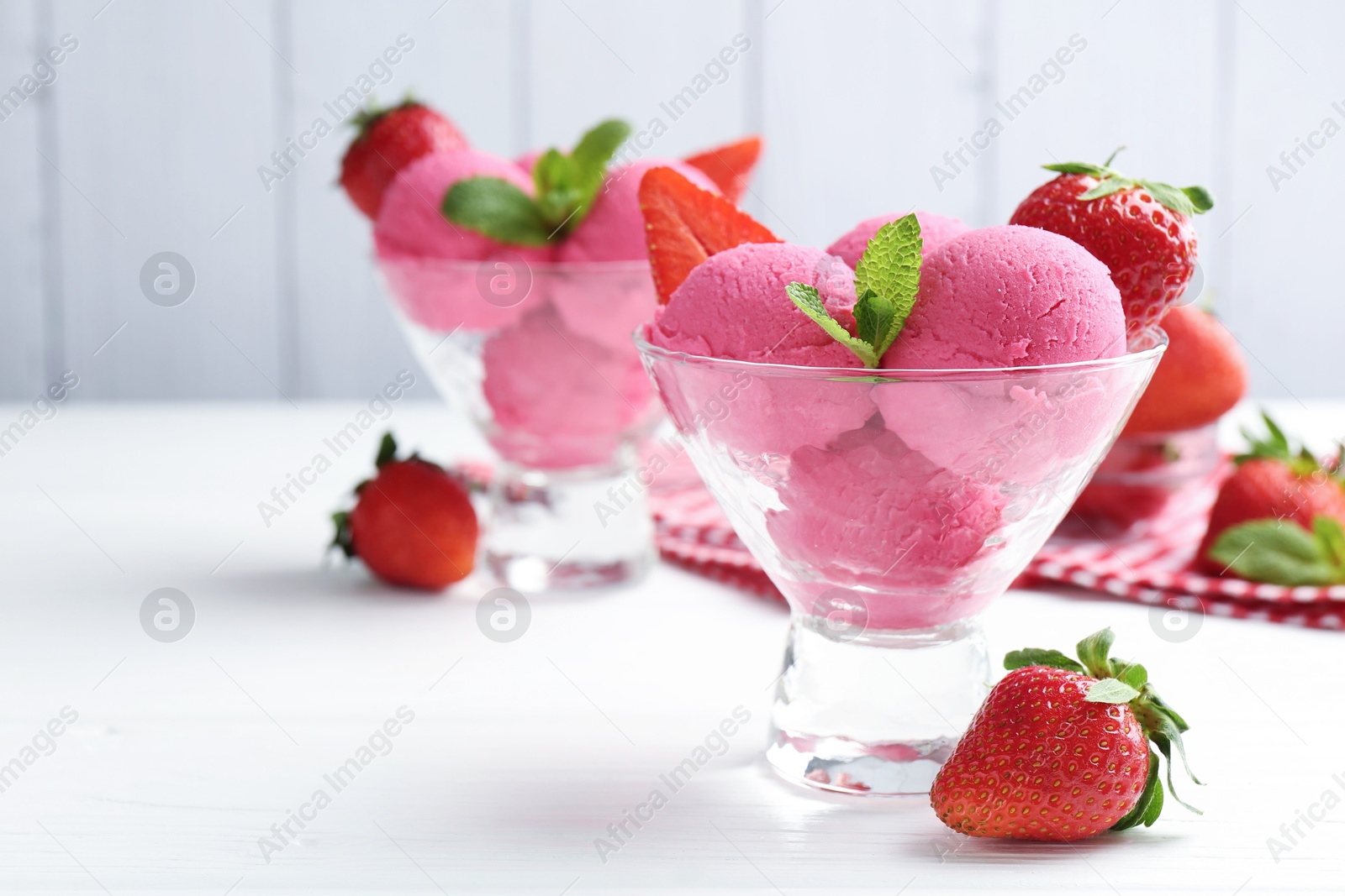 Refreshing sorbet, strawberries and mint in dessert bowls on white wooden table against grey background, closeup Photo of Refreshing sorbet, strawberries and mint in dessert bowls on white wooden table against grey background, closeup