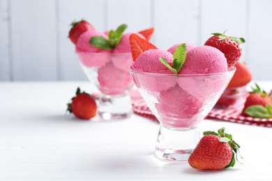 Photo of Refreshing sorbet, strawberries and mint in dessert bowls on white wooden table against grey background, closeup