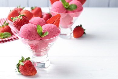 Photo of Refreshing sorbet, strawberries and mint in dessert bowls on white wooden table, closeup