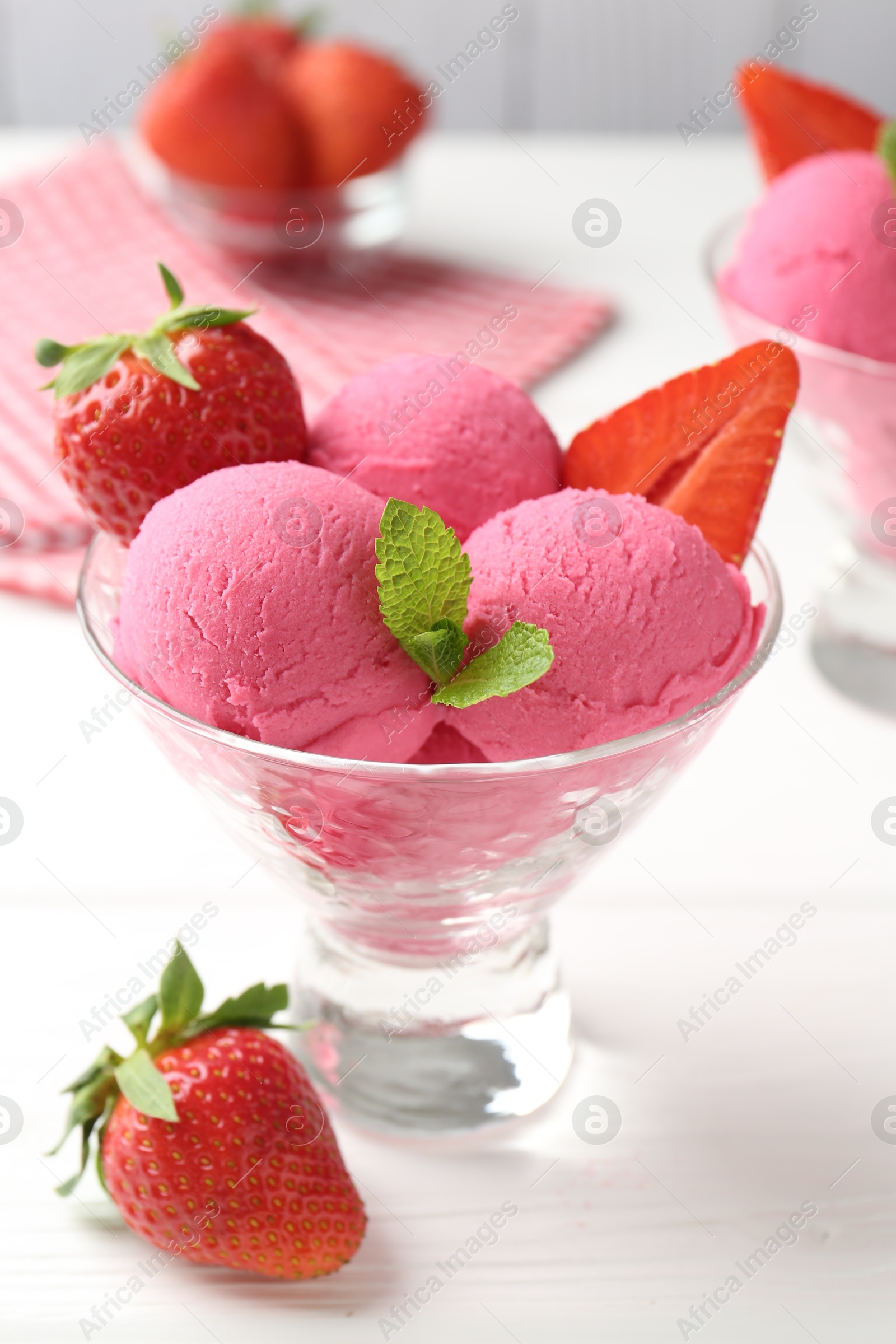 Refreshing sorbet, strawberries and mint in dessert bowl on white wooden table, closeup Photo of Refreshing sorbet, strawberries and mint in dessert bowl on white wooden table, closeup