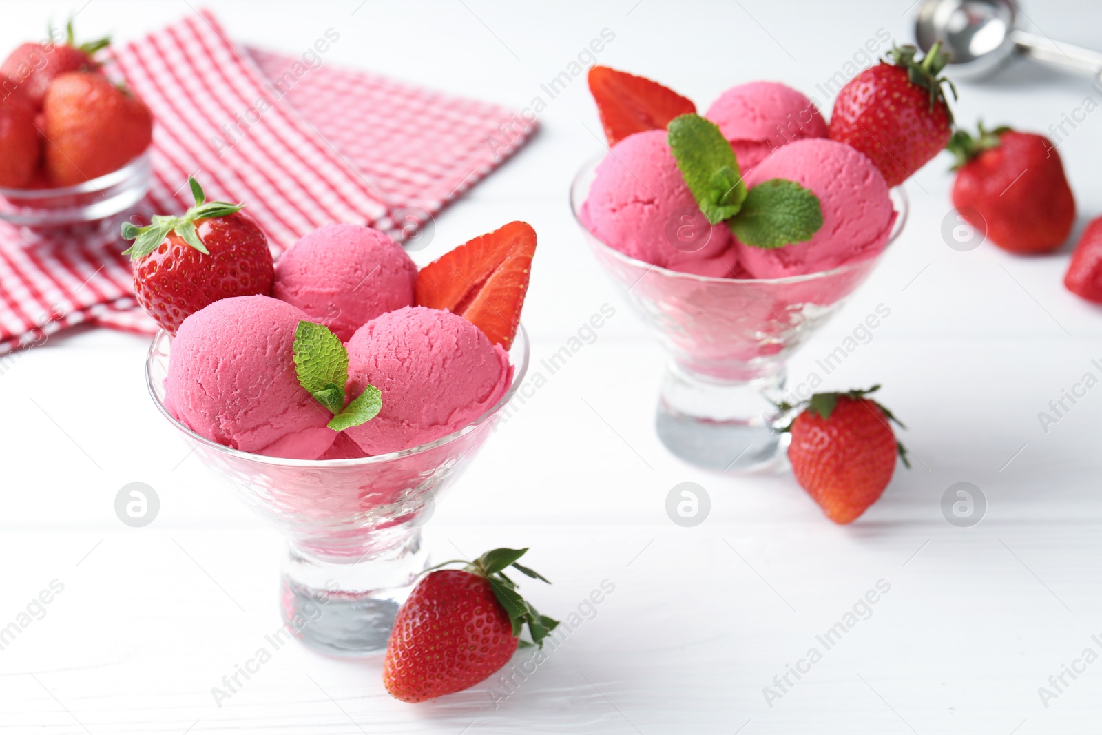 Refreshing sorbet, strawberries and mint in dessert bowls on white wooden table, closeup Photo of Refreshing sorbet, strawberries and mint in dessert bowls on white wooden table, closeup