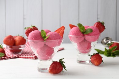Photo of Refreshing sorbet, strawberries and mint in dessert bowls on white wooden table against grey background, closeup