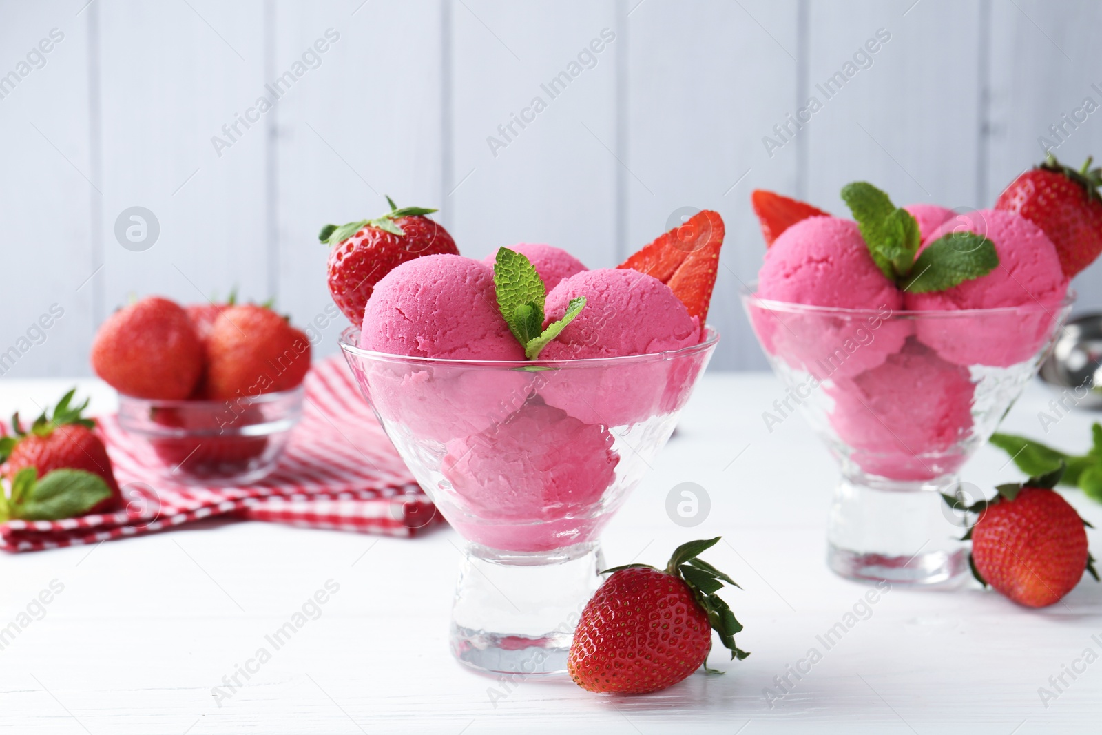 Refreshing sorbet, strawberries and mint in dessert bowls on white wooden table against grey background, closeup Photo of Refreshing sorbet, strawberries and mint in dessert bowls on white wooden table against grey background, closeup