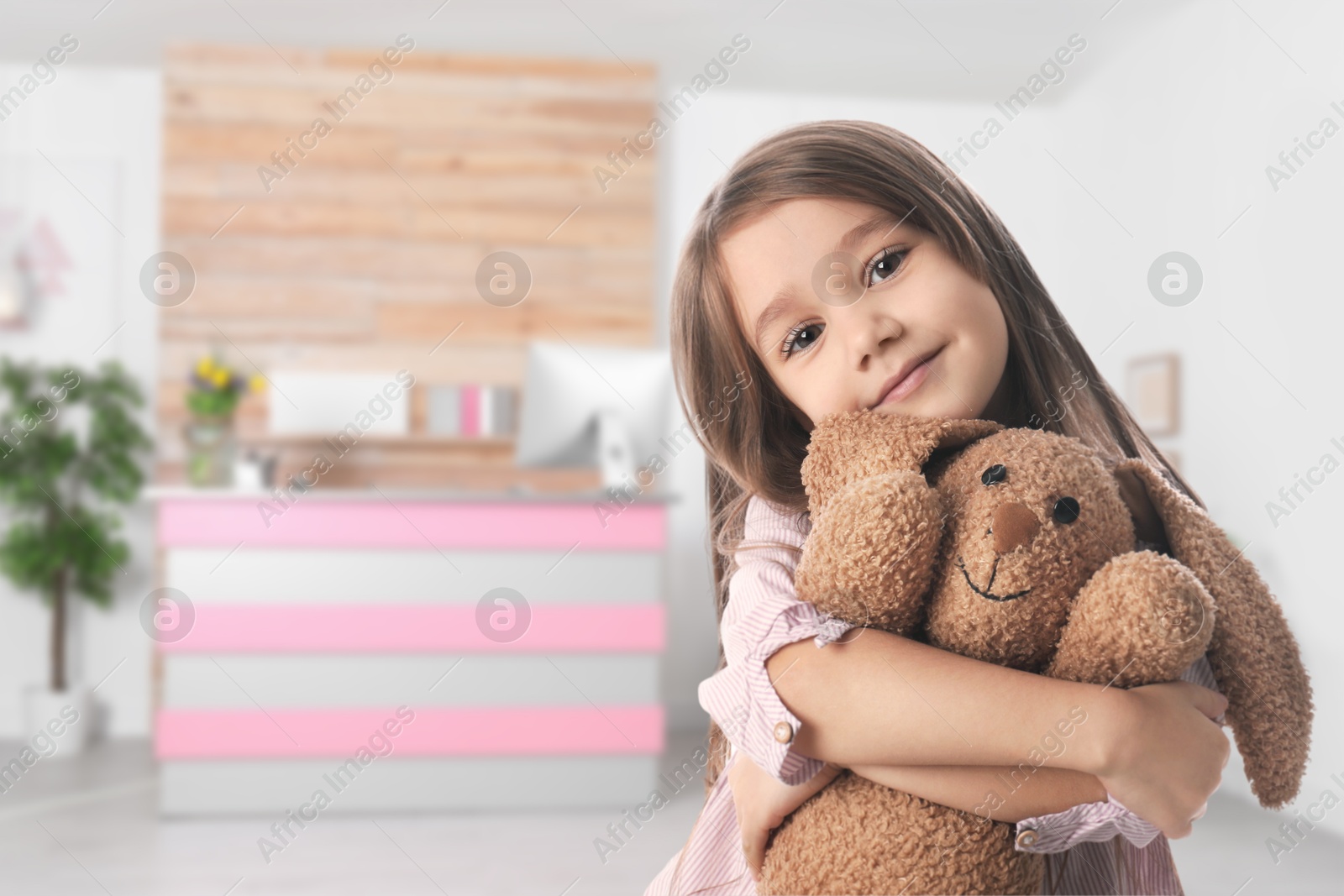 Image of Cute little girl with toy bunny in lobby of children's hospital