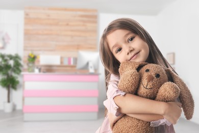 Image of Cute little girl with toy bunny in lobby of children's hospital