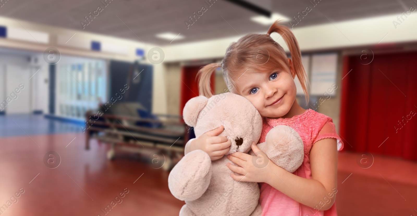 Image of Cute little girl with toy bear in hallway of children's hospital. Banner design