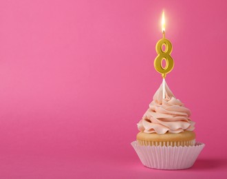 Image of Yummy cupcake with burning golden candle in shape of number 8 on pink background, space for text. Birthday or other special occasion