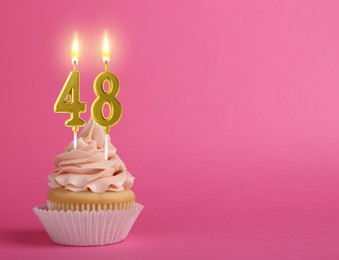 Image of Yummy cupcake with burning number shaped candles on pink background, space for text. 48th birthday or other special occasion