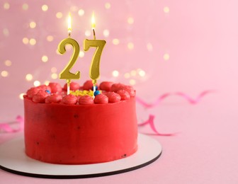 Image of Yummy cake with burning number shaped candles on pink background with blurred lights, space for text. 27th birthday or other special occasion