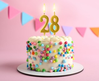 Image of Yummy cake with burning number shaped candles on pink background. 28th birthday or other special occasion