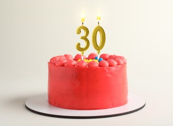 Image of Yummy cake with burning number shaped candles on white background. 30th birthday or other special occasion