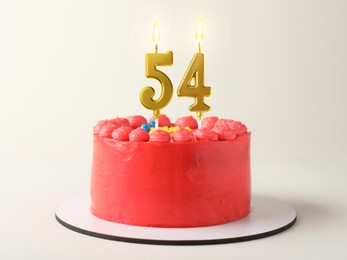 Image of Yummy cake with burning number shaped candles on white background. 54th birthday or other special occasion