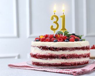 Image of Yummy cake with berries and burning number shaped candles on light table. 31th birthday or other special occasion
