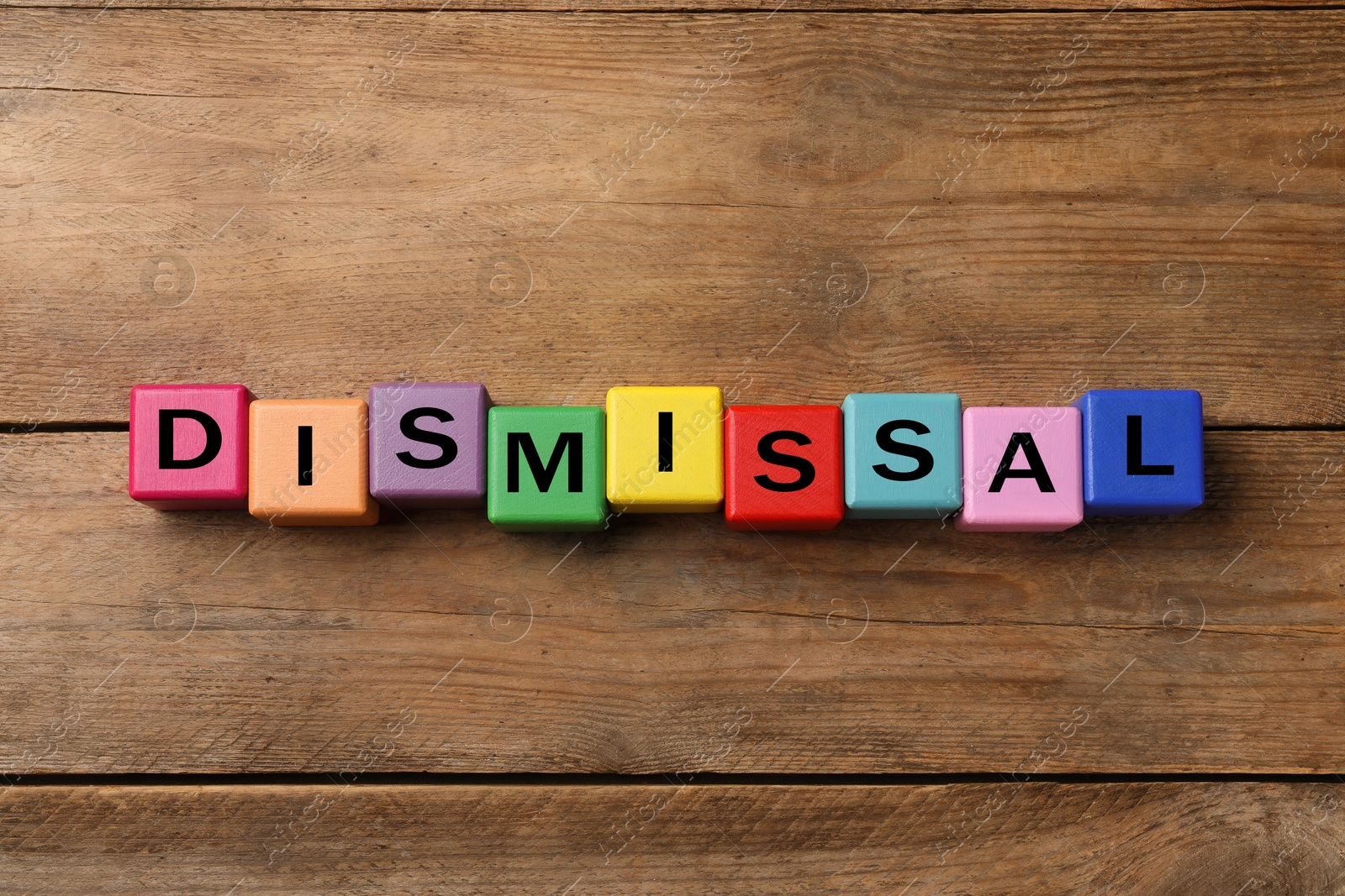 Image of Word Dismissal made of colorful cubes on wooden background, top view