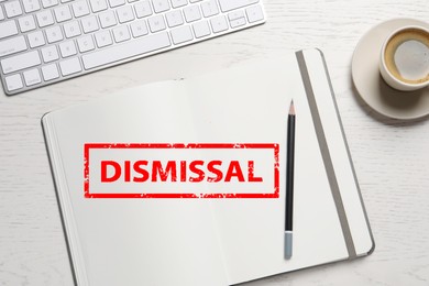 Image of Red stamp Dismissal in notebook on white wooden table, top view