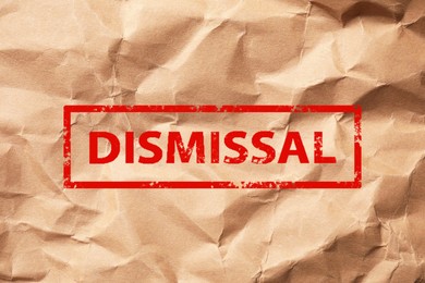 Image of Red stamp Dismissal on crumpled paper sheet, top view