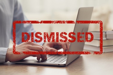 Image of Man using laptop at table and red stamp Dismissed, closeup