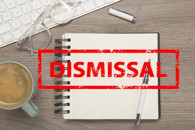 Image of Red stamp Dismissal over notebook on wooden table, top view