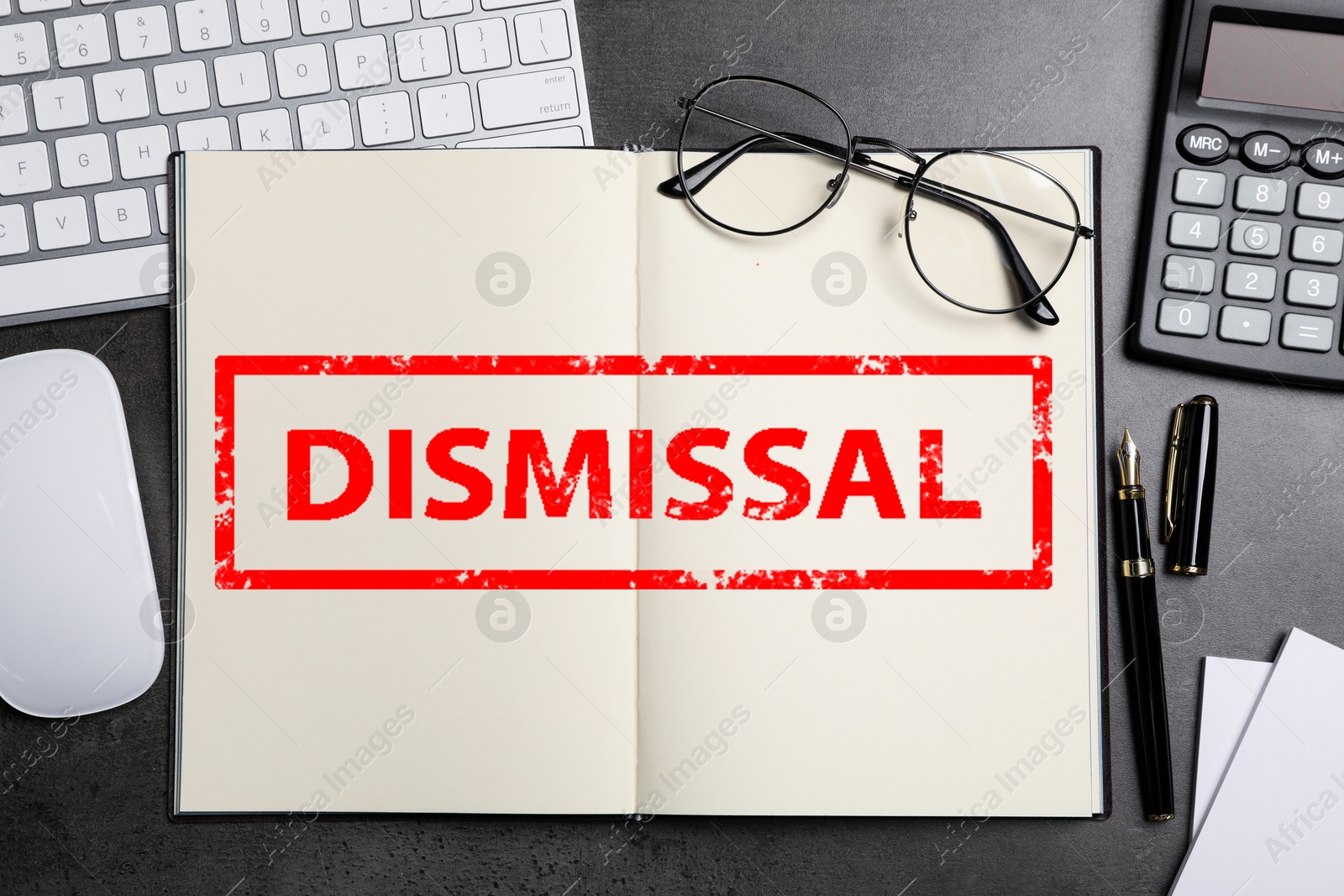 Word Dismissal in notebook on grey table. Office workplace, top view Image of Word Dismissal in notebook on grey table. Office workplace, top view