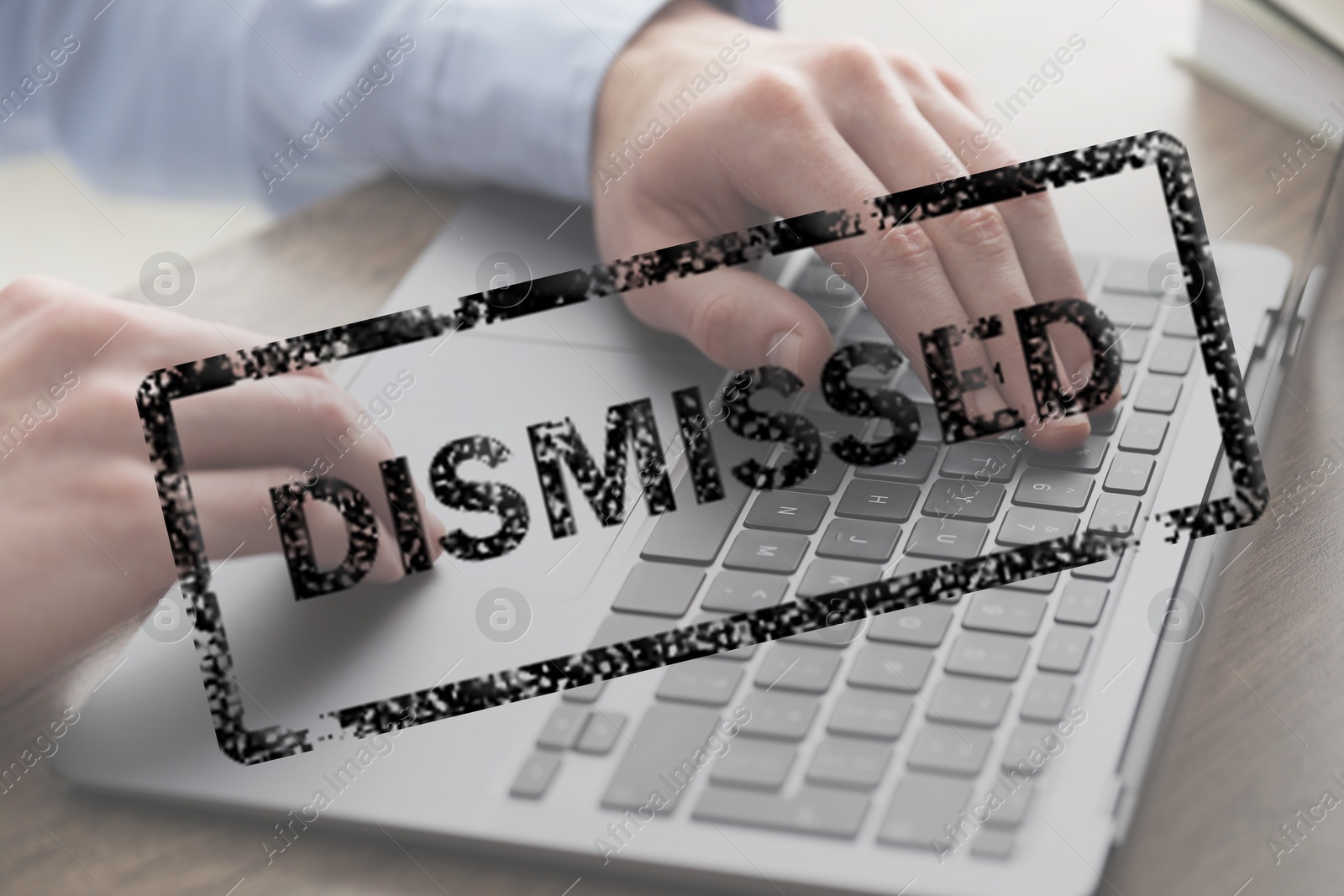 Man using laptop at table and black stamp Dismissed, closeup Image of Man using laptop at table and black stamp Dismissed, closeup