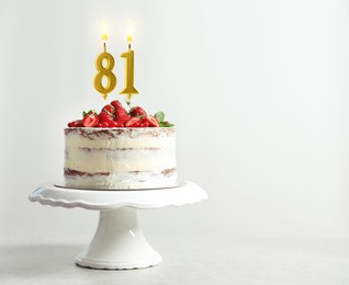 Image of Yummy cake with fruits and burning number shaped candles on white background, space for text. 81th birthday or other special occasion