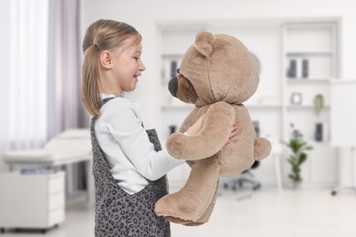 Image of Cute little girl with toy bear in pediatrician's office. Children's hospital
