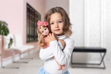 Image of Cute little girl with doll in hallway of children's hospital