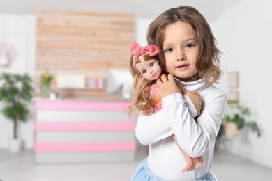 Image of Cute little girl with doll in lobby of children's hospital