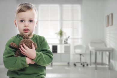 Image of Cute little boy with toy bear in pediatrician's office. Children's hospital