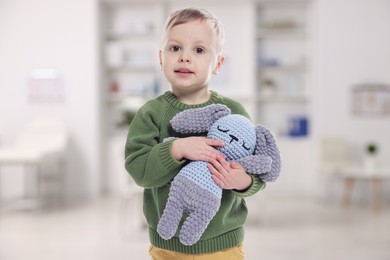 Image of Cute little boy with toy bunny in pediatrician's office. Children's hospital