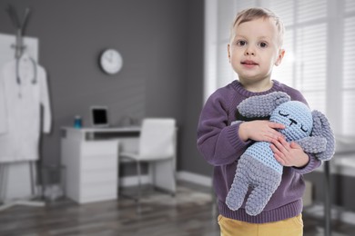 Image of Cute little boy with toy bunny in pediatrician's office. Children's hospital