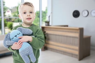 Image of Cute little boy with toy bunny in lobby of children's hospital
