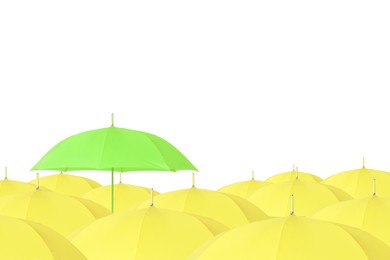 Image of Green umbrella among yellow ones against white background
