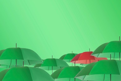 Image of Red umbrella among yellow green against color background